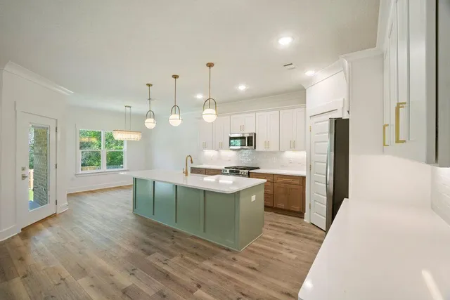 a kitchen with kitchen island a stove a sink and a refrigerator