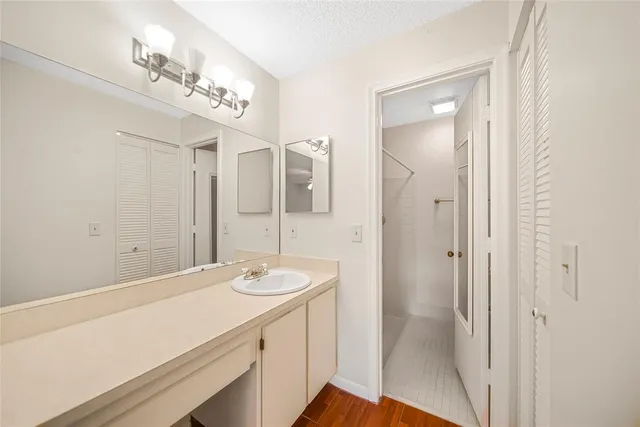 a bathroom with a sink a mirror and a shower