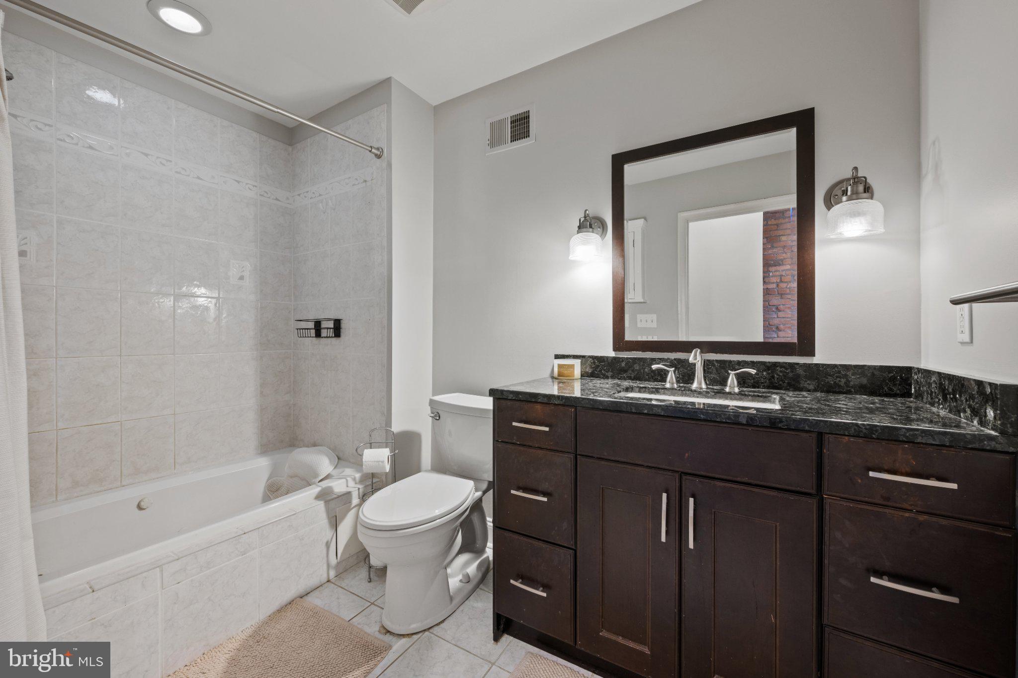 615 South Clinton Street Baltimore, MD 21224 - Photo 25 of 39 a bathroom with a bathtub shower sink mirror and toilet
