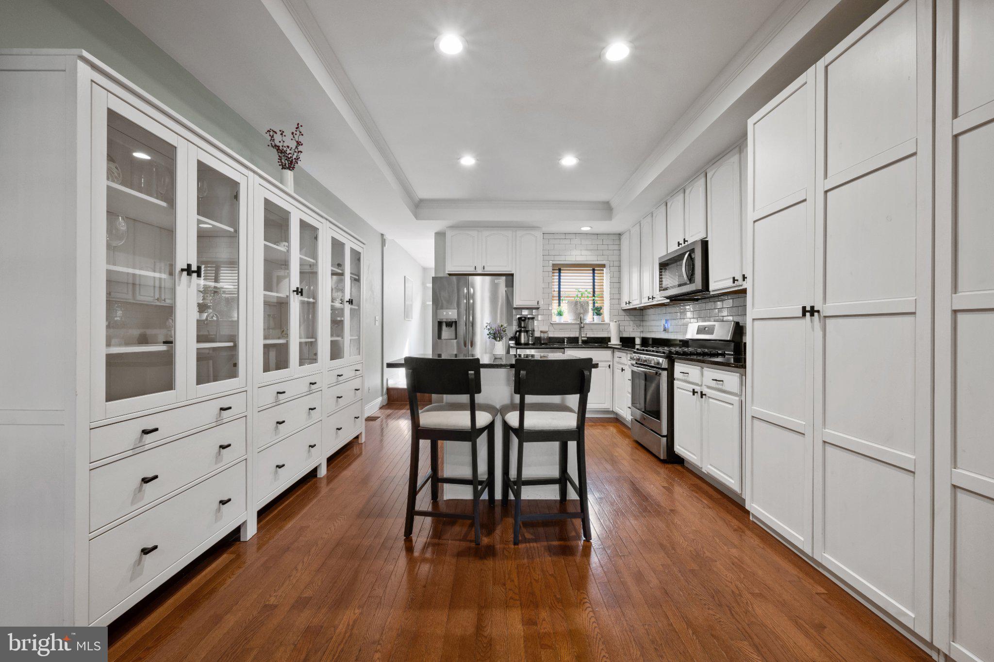 615 South Clinton Street Baltimore, MD 21224 - Photo 5 of 39 a kitchen with white cabinets and wooden floor
