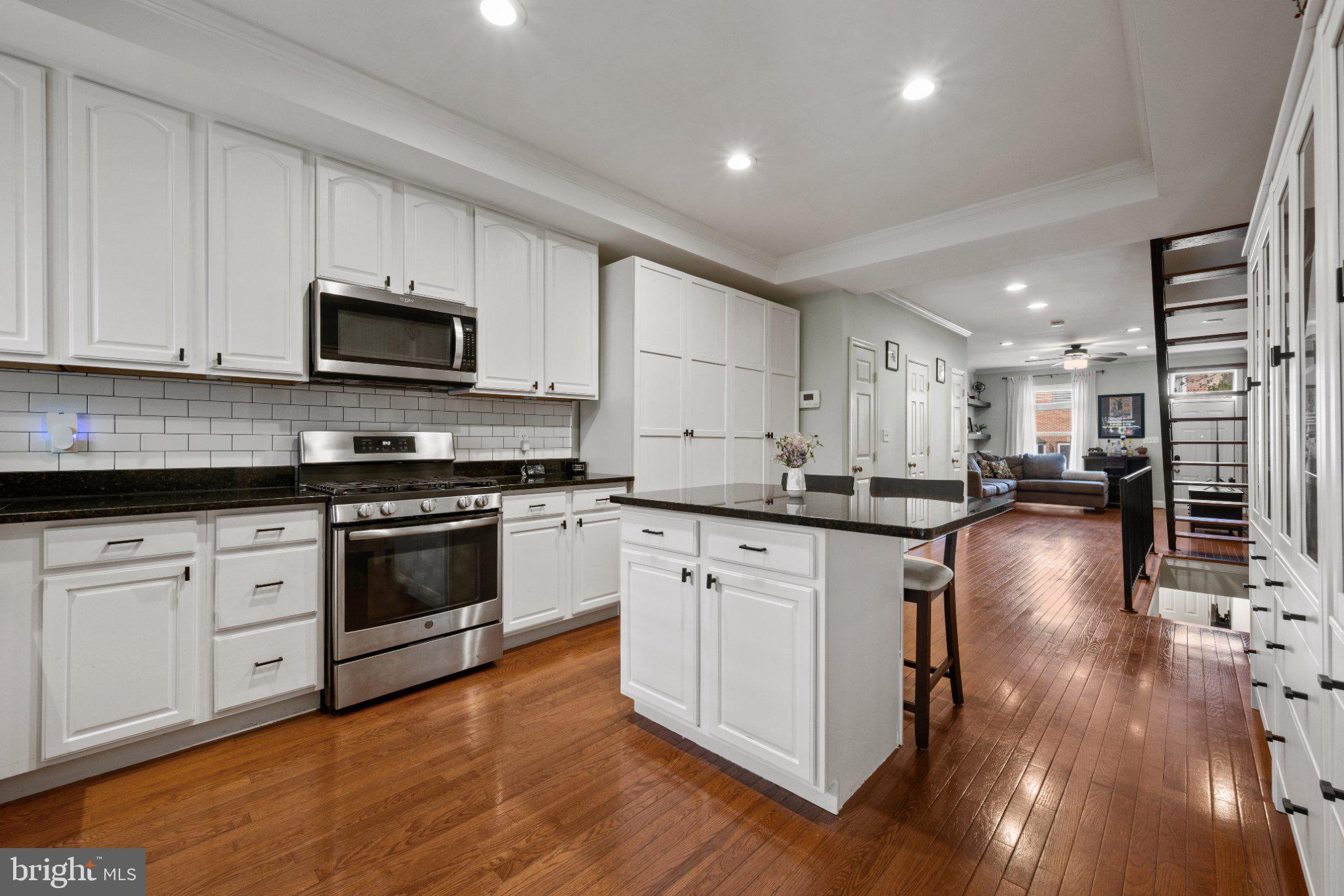 615 South Clinton Street Baltimore, MD 21224 - Photo 8 of 39 a kitchen with stainless steel appliances a stove a sink a refrigerator white cabinets and wooden floor