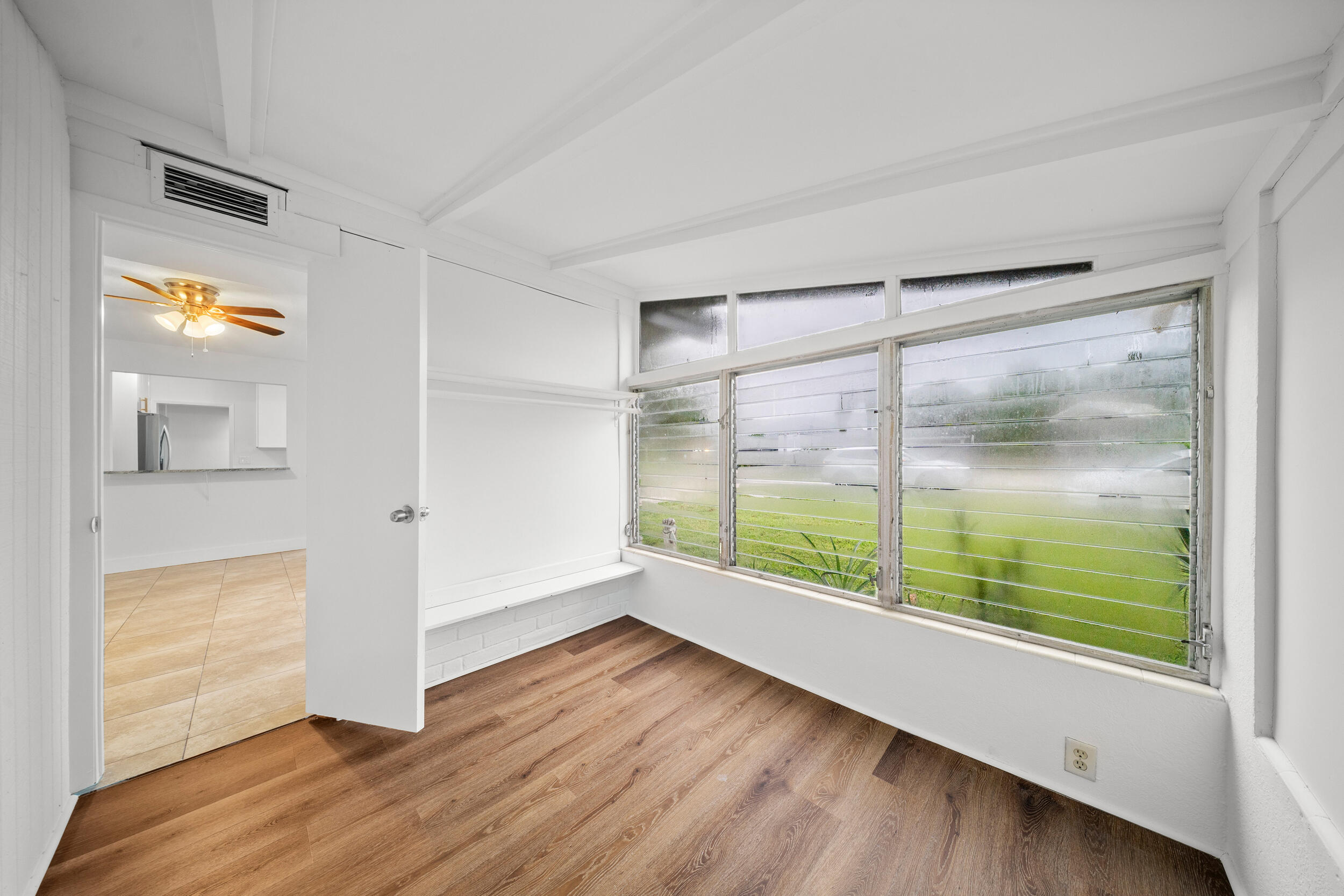 2904 Southeast Bamboo Street Stuart, FL 34997 - Photo 16 of 51 a view of an empty room with wooden floor and a window