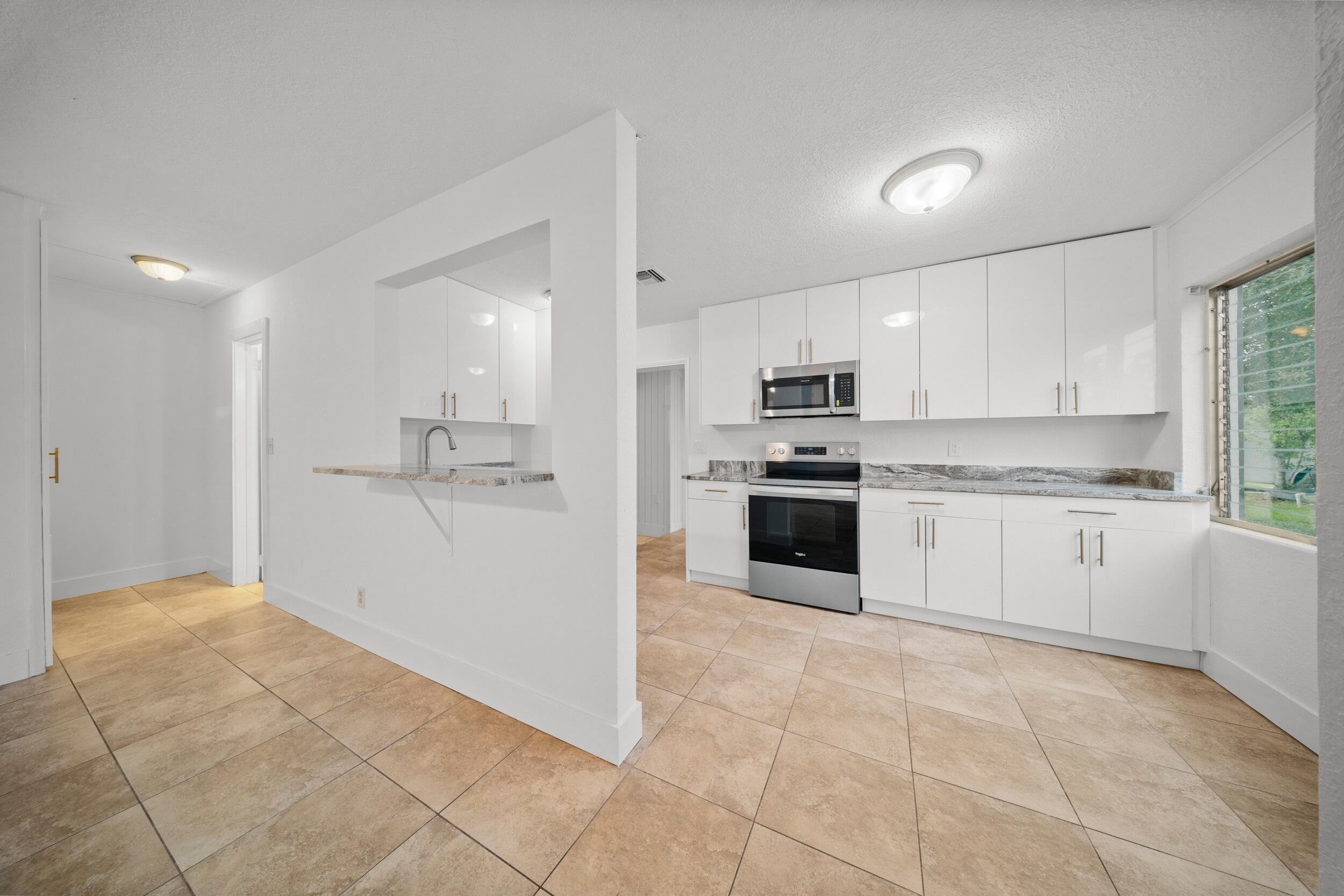2904 Southeast Bamboo Street Stuart, FL 34997 - Photo 10 of 51 a large kitchen with cabinets and stainless steel appliances