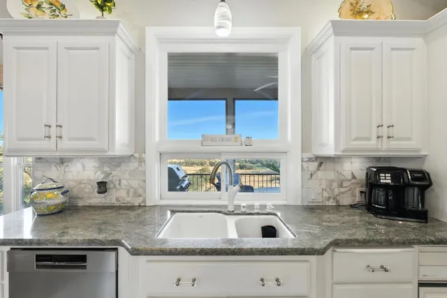 a kitchen with stainless steel appliances granite countertop a sink and cabinets
