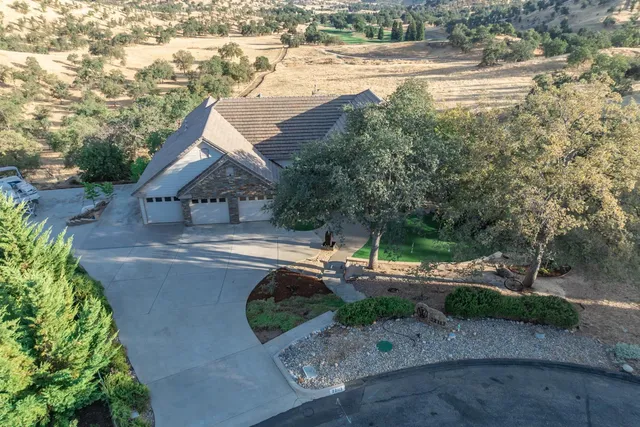 an aerial view of house with yard and mountain view in back