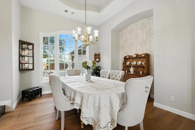 a view of a dining room with furniture wooden floor and chandelier
