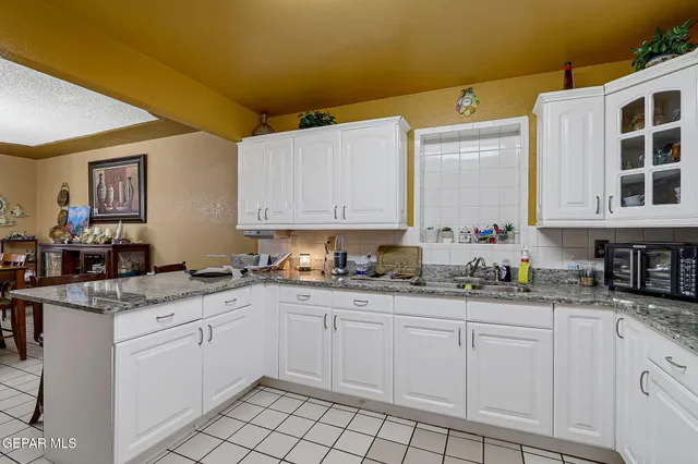 a kitchen with granite countertop a sink and cabinets