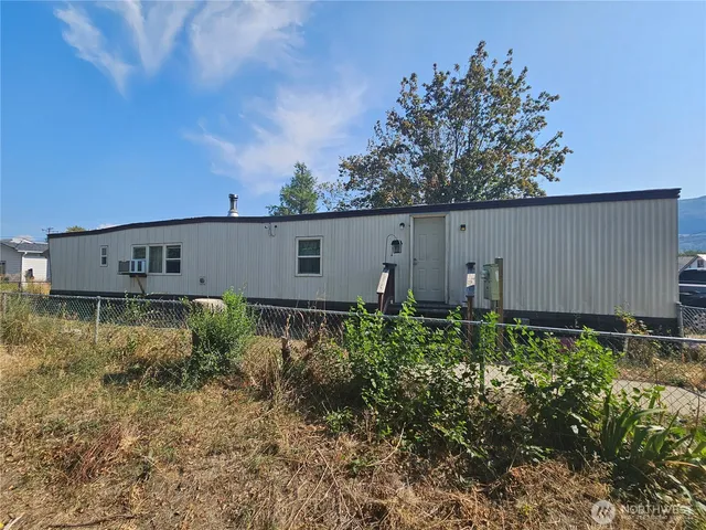 a view of road with card parked on side and retail shops