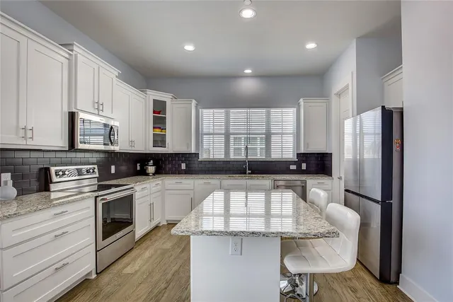 a kitchen with a refrigerator and a stove top oven