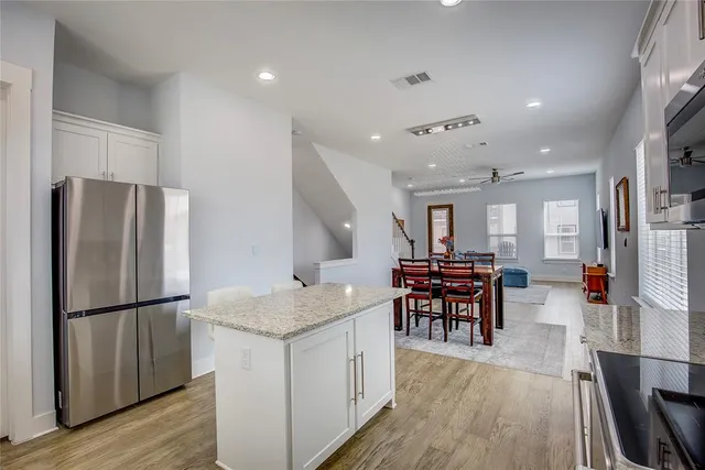 a kitchen with stainless steel appliances granite countertop furniture wooden floor and a refrigerator