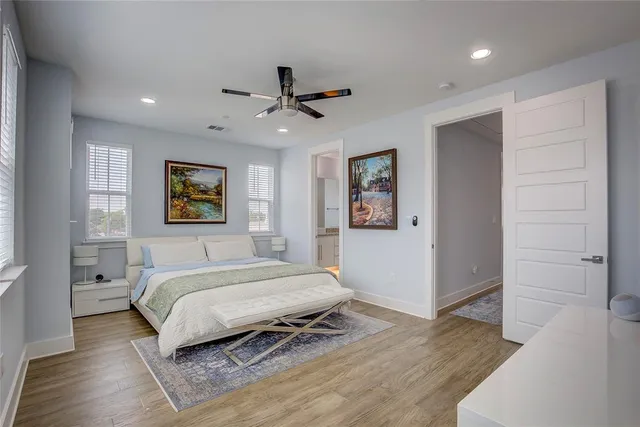 a bedroom with a large bed and a ceiling fan