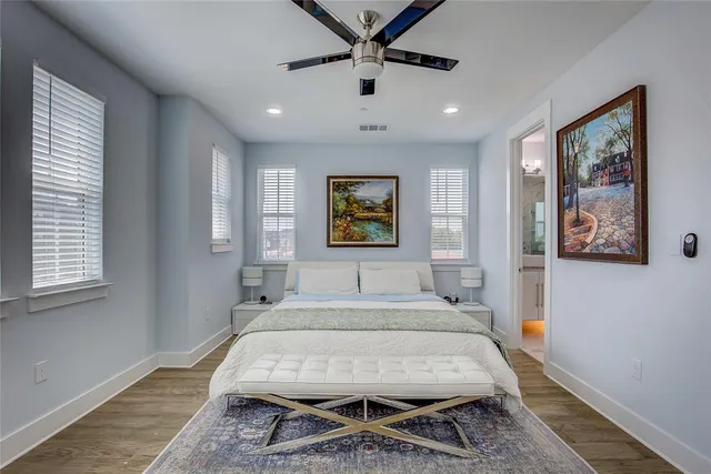 a bed sitting in a spacious bedroom next to a window