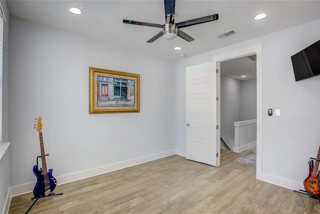 a view of room with wooden floor and ceiling fan