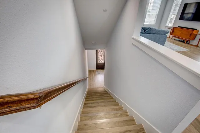 a hallway with stairs and wooden floor