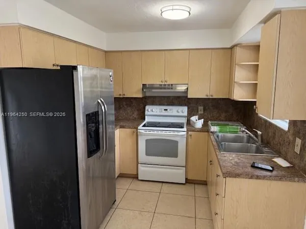 a kitchen with a refrigerator sink and stove
