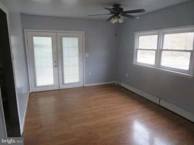 an empty room with a window and a fan
