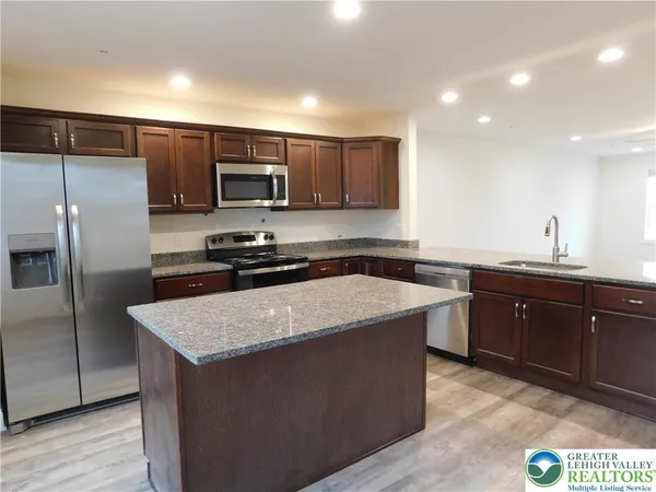 a kitchen with a sink a microwave a refrigerator and cabinets