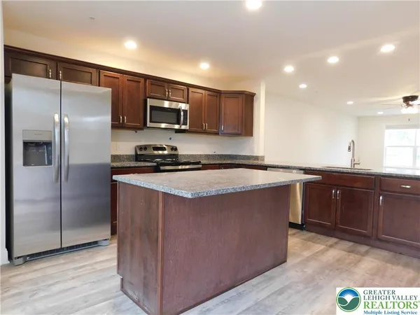 a kitchen with stainless steel appliances granite countertop a stove a sink and a refrigerator