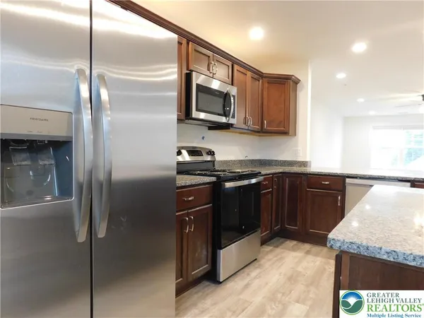 a kitchen with stainless steel appliances granite countertop a refrigerator and a sink