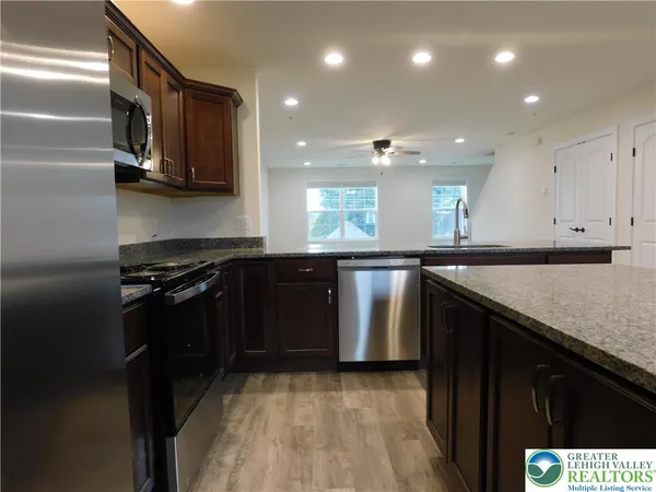 a kitchen with stainless steel appliances granite countertop a sink and a stove