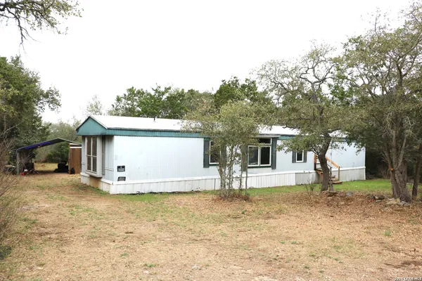 a view of a house with backyard and tree