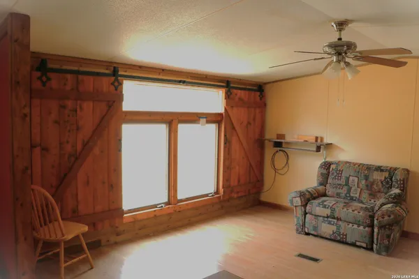 a living room with furniture a ceiling fan and a window