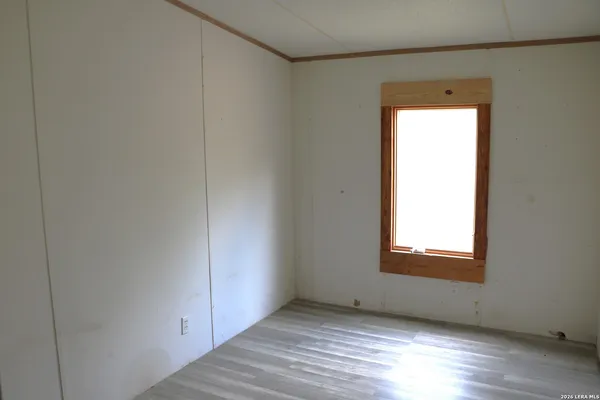 an empty room with wooden floor and a window