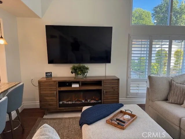 a living room with furniture a flat screen tv and a fireplace