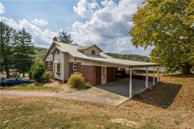a front view of house with yard and trees around