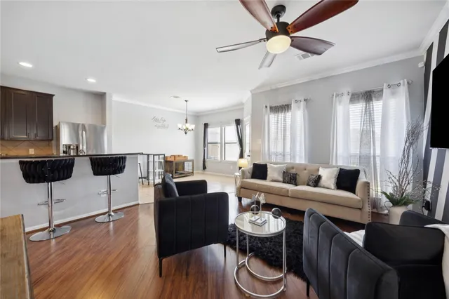a living room with furniture kitchen view and a chandelier