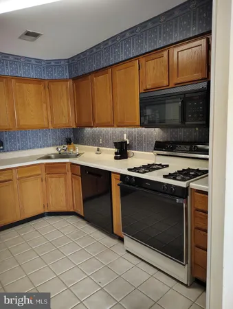 a kitchen with a sink a counter space and cabinets