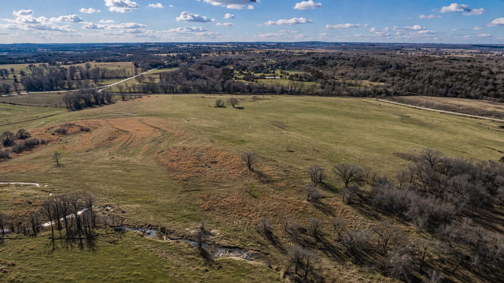 2 West Fern Mountain Road Muskogee, OK 74401 - Photo 53 of 55 Expansive open fields with varied ground cover, mature trees bordering a natural water feature, and distant tree lines