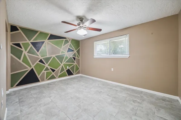 a view of an empty room with a ceiling fan