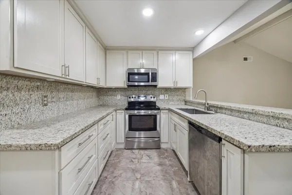 a view of a kitchen with a sink and a refrigerator