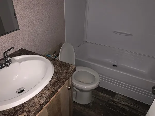 a bathroom with a granite countertop sink toilet and a bathtub