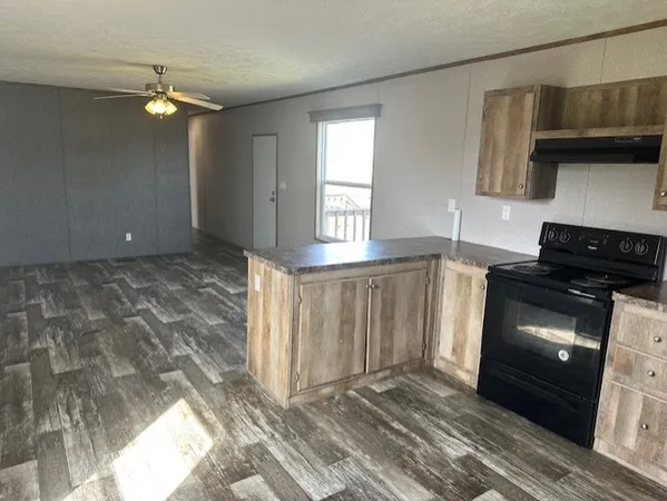 a kitchen with granite countertop a stove a sink and a microwave
