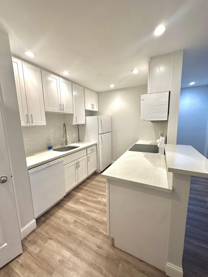401 Piccadilly Place, Unit 9 San Bruno, CA 94066 - Photo 3 of 8 a kitchen with a sink a refrigerator and white cabinets