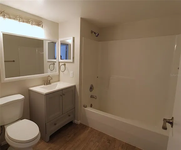 a bathroom with a sink mirror vanity and toilet