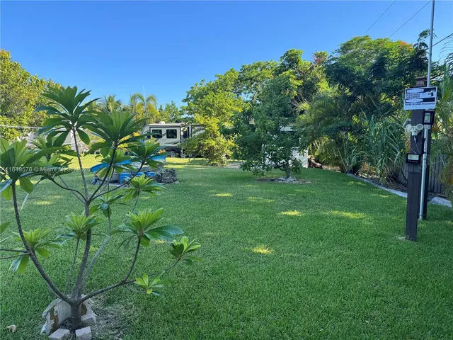 a green field with lots of trees in front of it