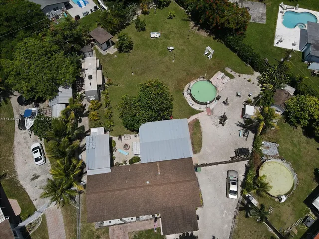 an aerial view of a house with swimming pool and outdoor seating