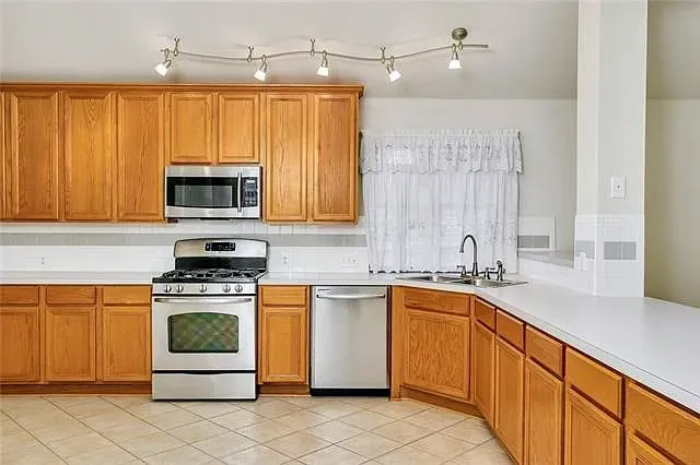 a kitchen with stainless steel appliances a stove sink and microwave