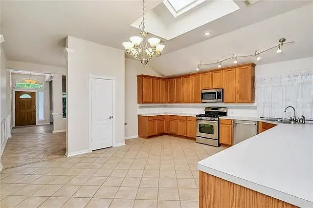 a kitchen with stainless steel appliances a stove refrigerator sink and microwave