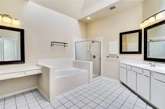 a bathroom with a bathtub a sink a vanity and a mirror