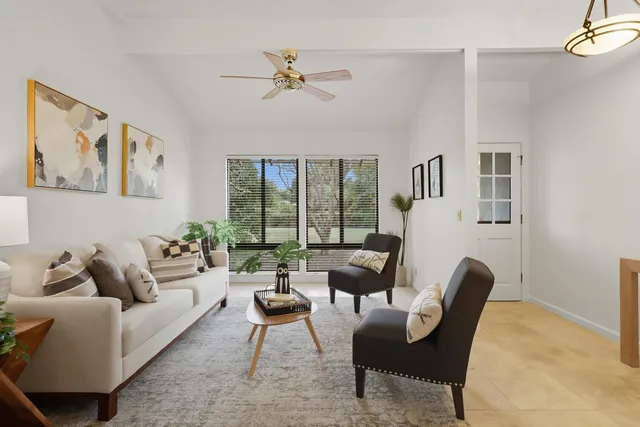 a living room with furniture couches and a dining table with wooden floor