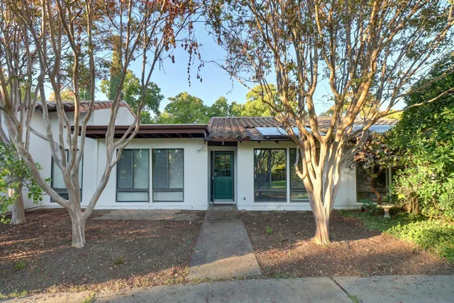 a front view of a house with a tree