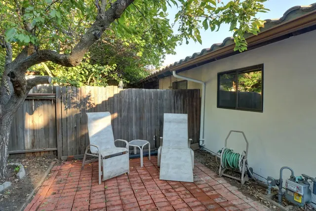 a view of a patio with table and chairs with wooden fence and plants