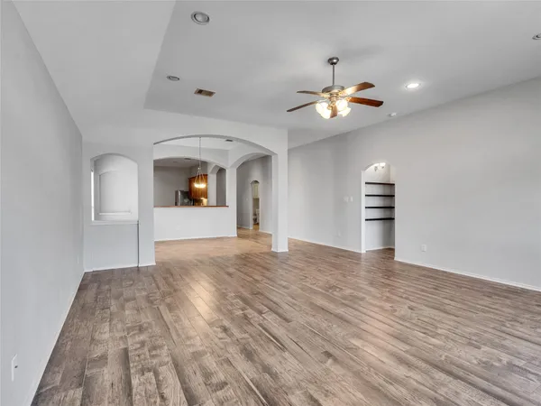 a view of empty room with wooden floor and window