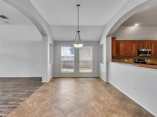 a kitchen with stainless steel appliances granite countertop a stove a sink dishwasher and a microwave oven with cabinets