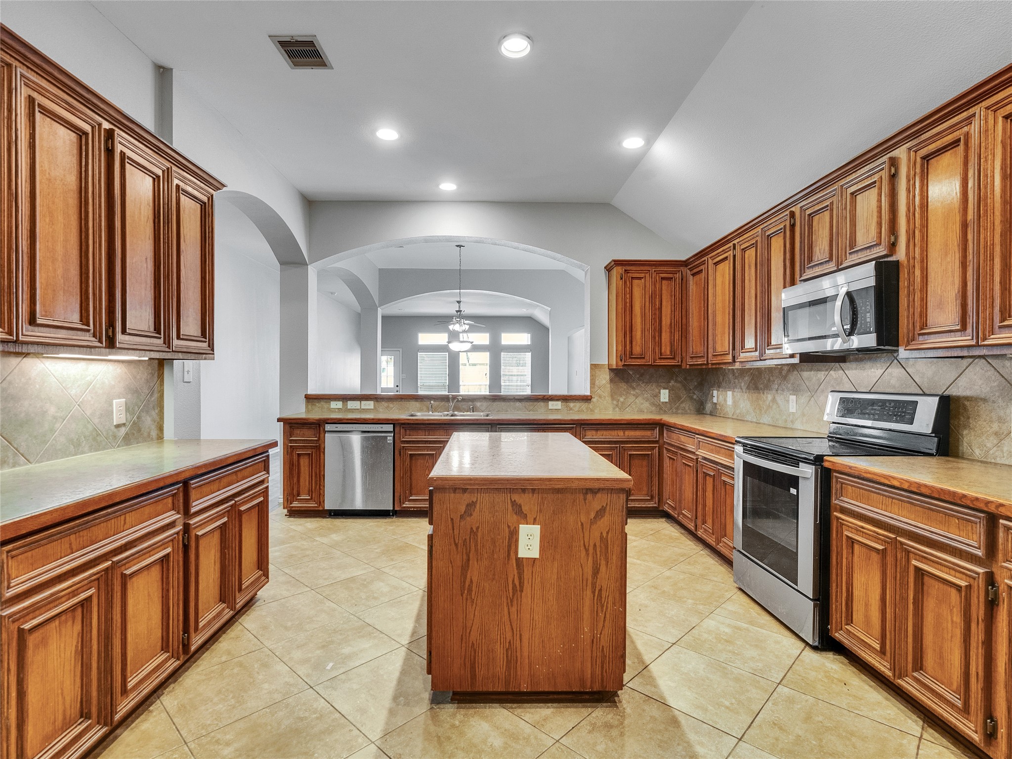 5643 Walnut Glen Lane Rosenberg, TX 77471 - Photo 27 of 42 a kitchen with stainless steel appliances granite countertop a stove a sink dishwasher and a microwave oven with cabinets