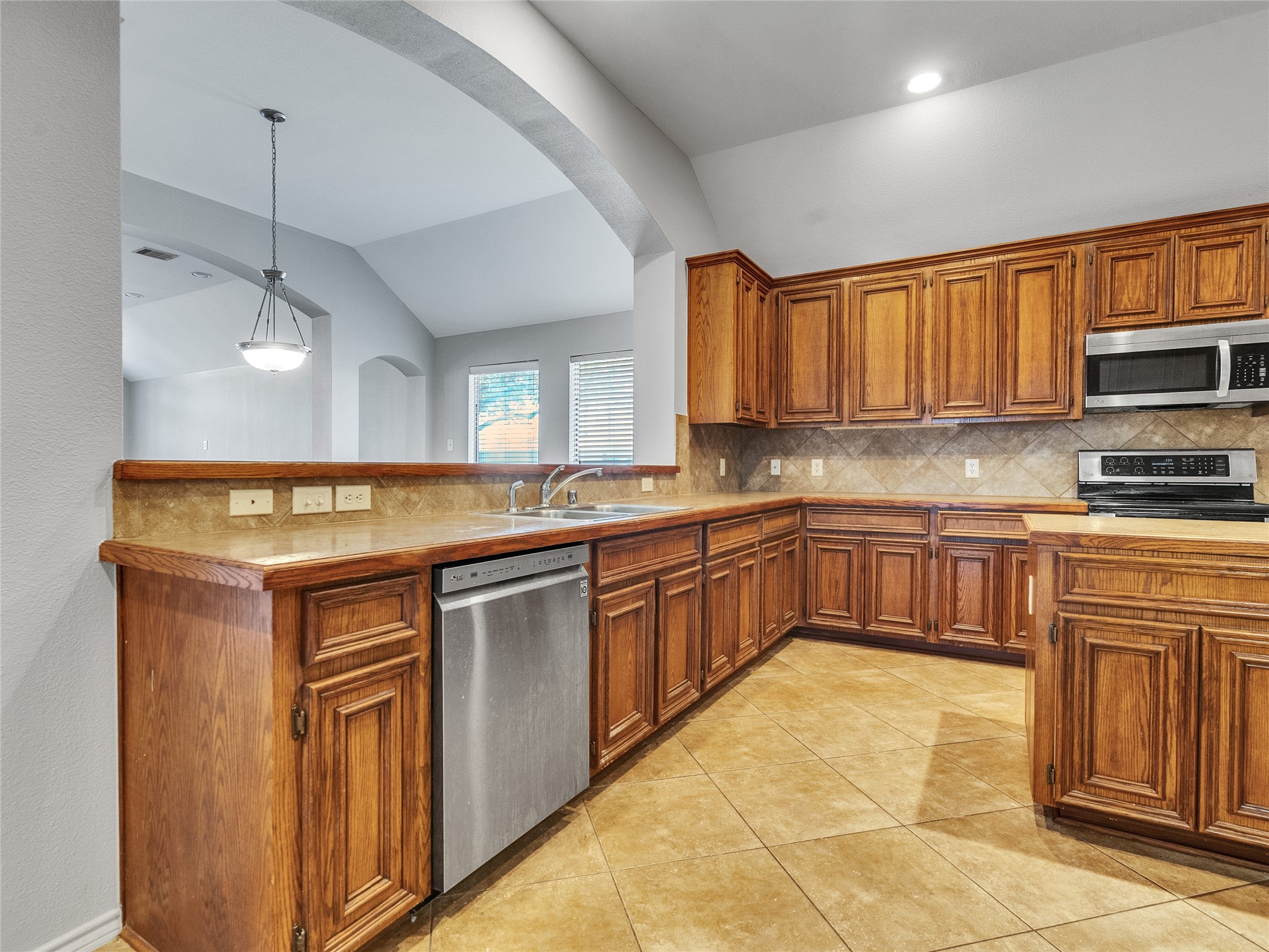 5643 Walnut Glen Lane Rosenberg, TX 77471 - Photo 30 of 42 a kitchen with stainless steel appliances granite countertop a sink a stove cabinets and a refrigerator